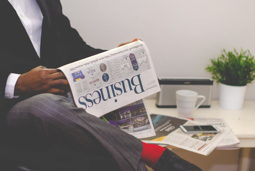 Man in Suit Reading Business News Paper