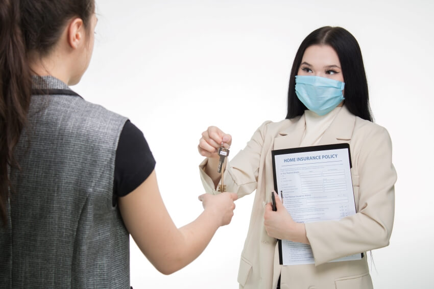 Woman in Mask Handing Keys