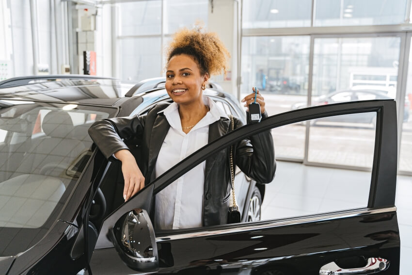 Woman Holding a Car Key Next to Car