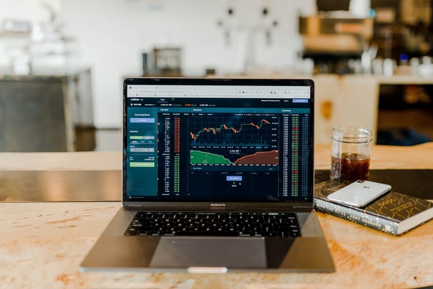 Laptop with Stocks Chart Display and a Cup of Coffee