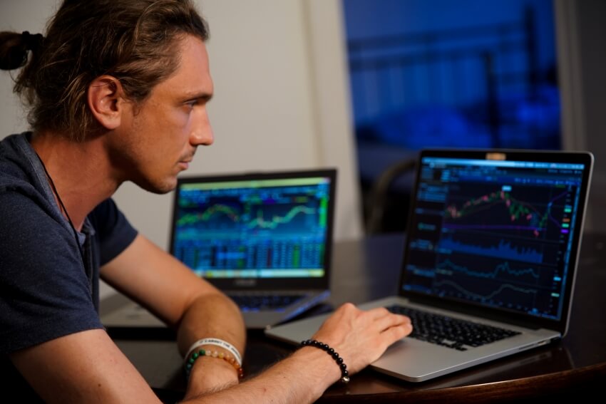 Man with Two Laptop Showing Stocks Chart