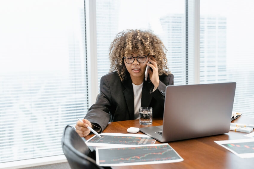 Woman Checking Printed Stocks Graph