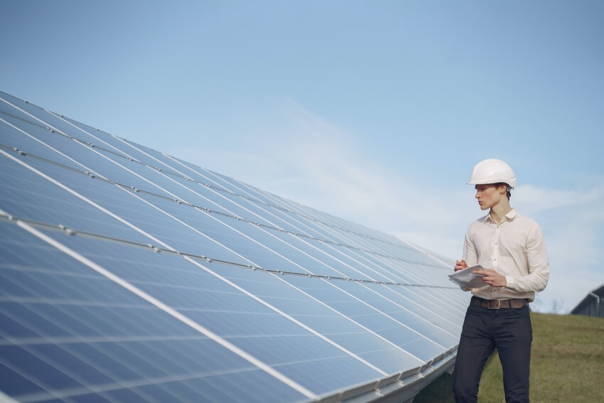 Man with White Hard Hat Looking at the Solar Panels