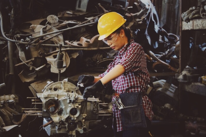 Woman Fixing a Machine Part