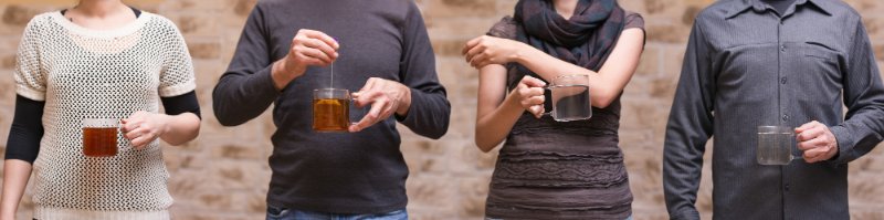 four people with teaglasses are sharing a teabag