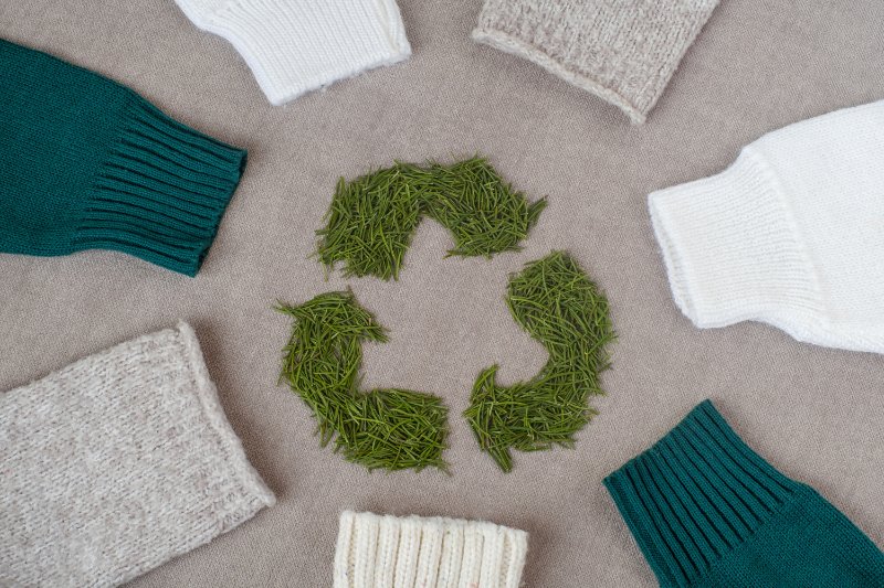 sleeves with winter knitted sweaters and a recycling sign in middle