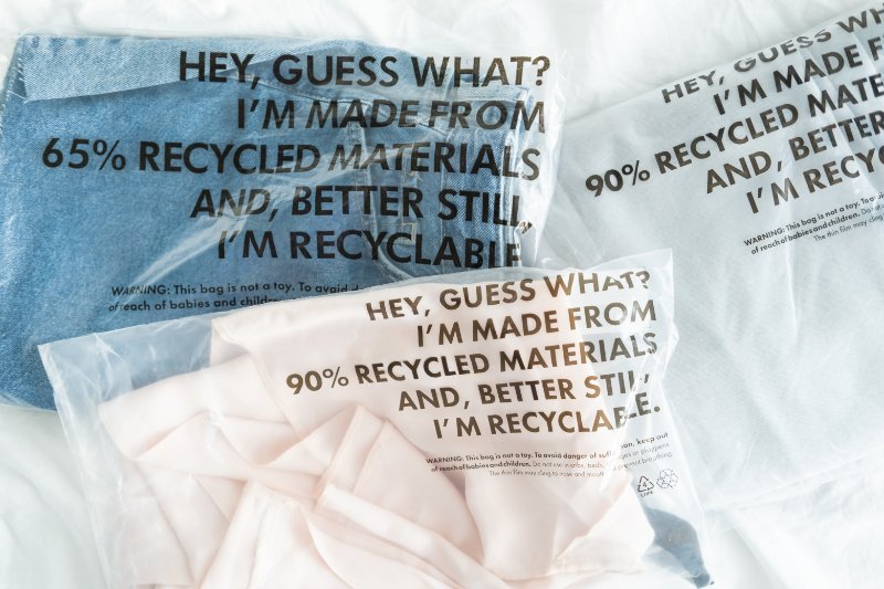 Clothes in plastic bag with tag recycled materials and recyclable