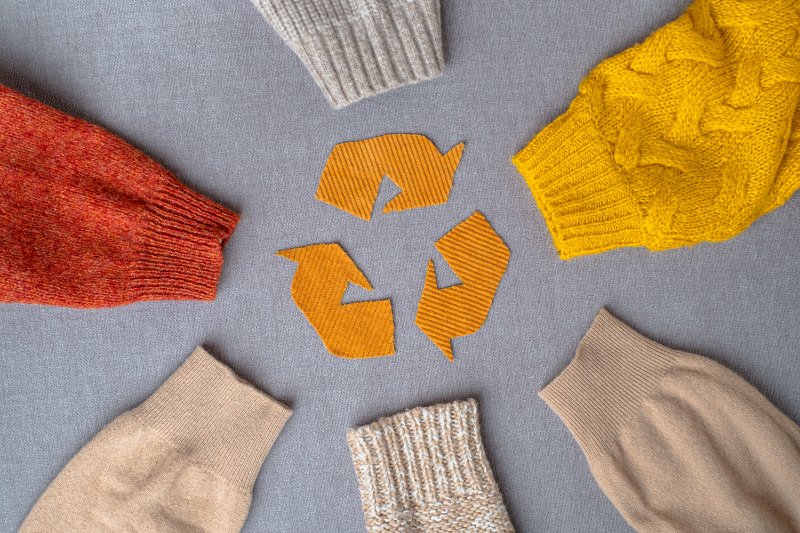 recycle icon in the middle of sleeves of autumn woolen sweaters
