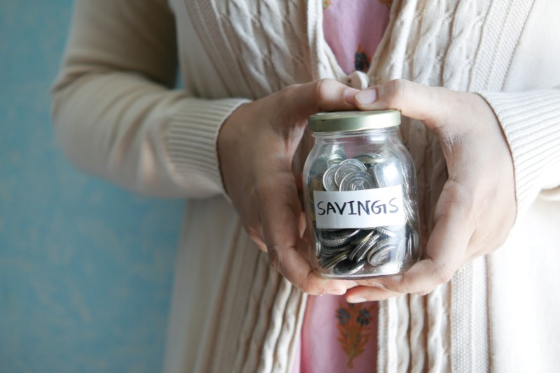 Woman holding a jar with coins