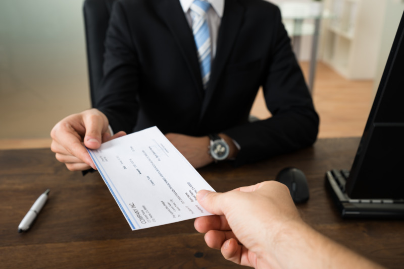 Man handing a cheque