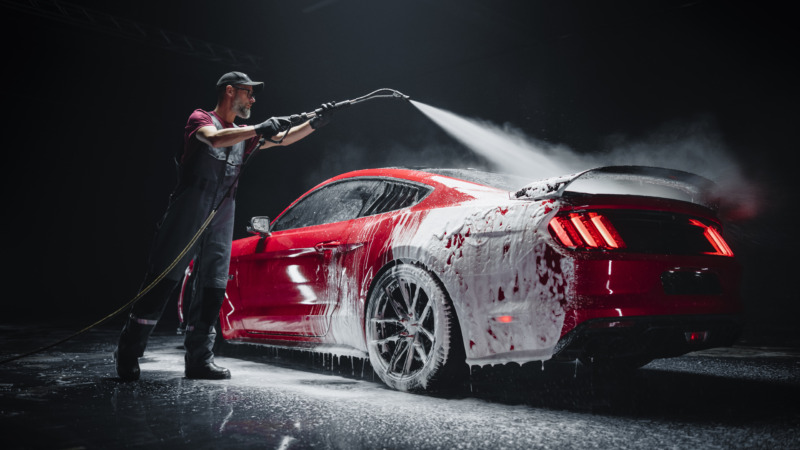 Man washing a red car