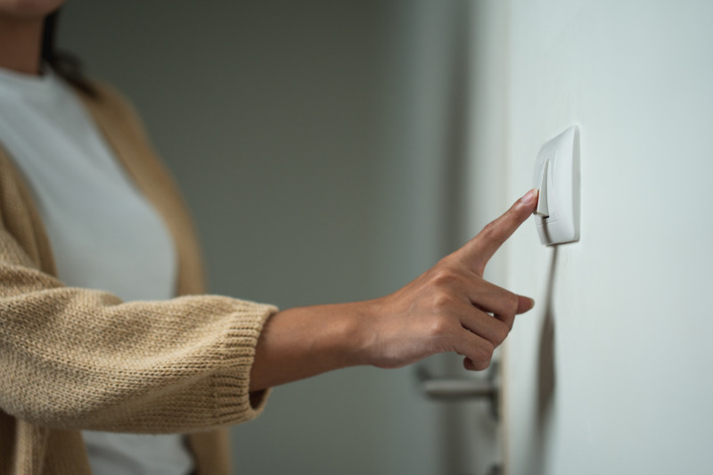 Woman turning the light switch off